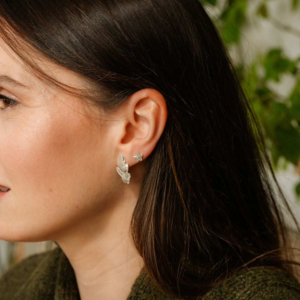 Close-up of a woman wearing silver earrings with a blurred background