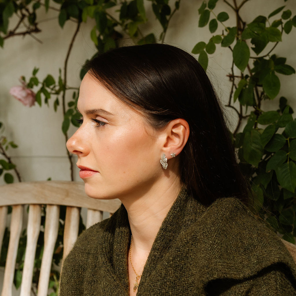 Woman sitting outdoors with greenery in the background